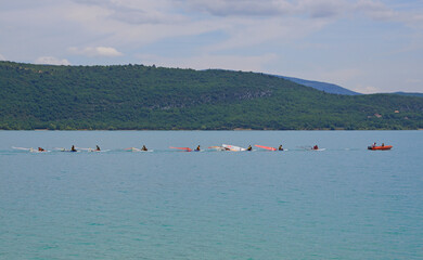 Schüler einer Windsurf-Schule am Lac de Sainte-Croix (Frankreich) werden von einem Boot gemeinsam...