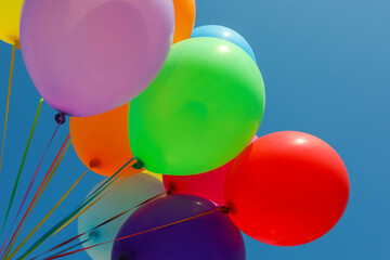 Bunch of colorful balloons against blue sky, low angle view