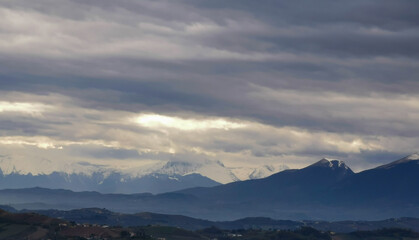 Nuvole grigie sopra le montagne innevate