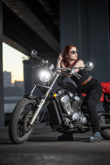 Obraz na płótnie Canvas Girl biker sexually posing on motorcycle at night city