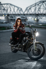 Plakat Girl biker sexually posing on motorcycle at night city