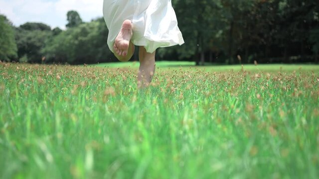 緑に囲まれた草原を走る女の子