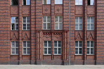 Fototapeta na wymiar Exterior front street view of rough vintage red brick classical facade of typical old building in Berlin, Germany.