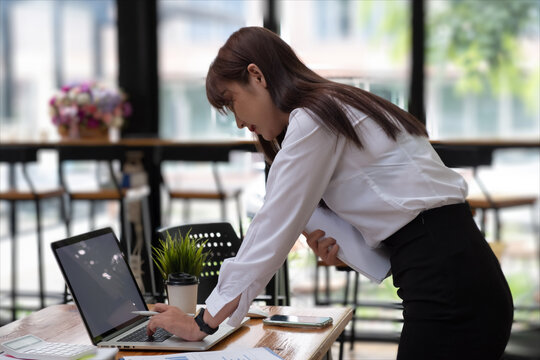 Portrait of a female office worker concentrating on her work with a digital tablet and stationery in the office room. .
