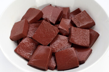 Pork blood pudding in white bowl on white background.