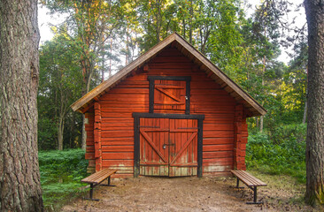 Fototapeta na wymiar Old wooden red storage cabin in a forest 