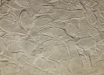 footprints and hiking tennis trainers shoe prints marks in beach sand dunes