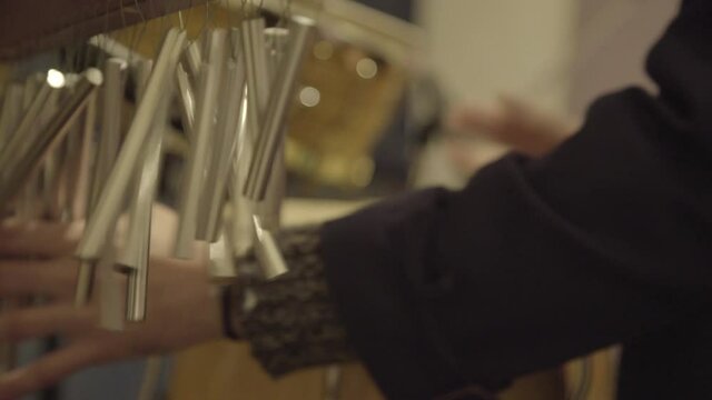 Close up view of drummer giving special effects with bar chimes during live performance.