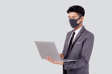 Young asian business man in face mask using laptop computer isolated on white background, quarantine and epidemic covid-19, businessman work from home for health, social distancing, new normal.