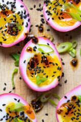 Beet pickled jammy eggs with black sesame seeds and green onions