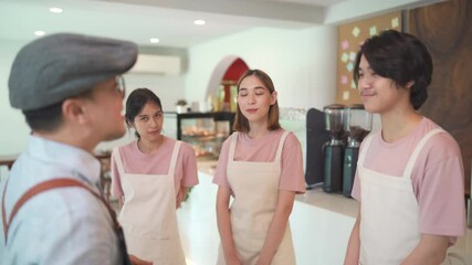 4K Asian male coffee shop manager briefing man and woman staff team before working. Small business cafe and restaurant owner instruct part time employee preparing service to customers before opening