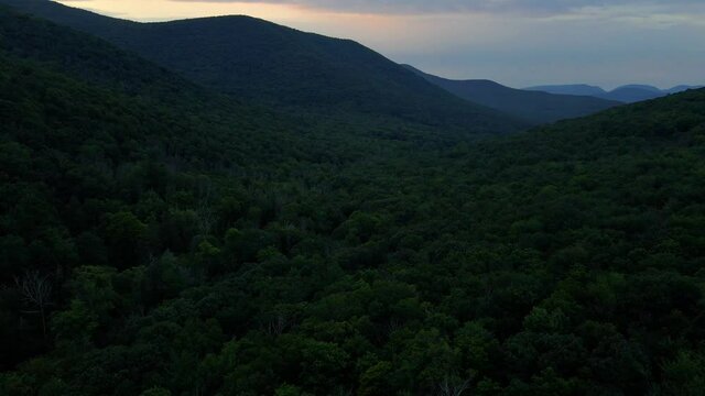 Aerial drone video footage of the Appalachian mountains after sunset during warm summer nights. This is in New York's Hudson Valley in the Catskill Mountain sub-range.