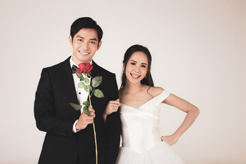 Young attractive Asian couple, soon to be bride and groom, woman wearing white wedding gown. Man...
