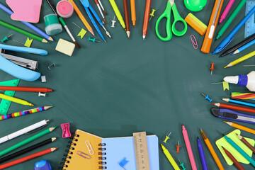 Stationery lies in a circle on a green background. Kids stationery on school board. Over view, flat lay.
