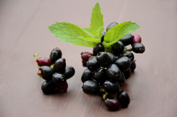 closeup blackberry fruit with green mint over out of focus brown background.