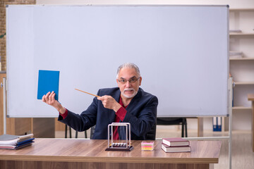Old teacher physicist sitting in the classroom