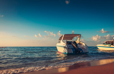 Speed boat at the sea beach and sunset.