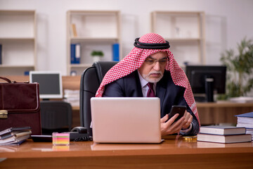 Aged arab businessman employee sitting at workplace