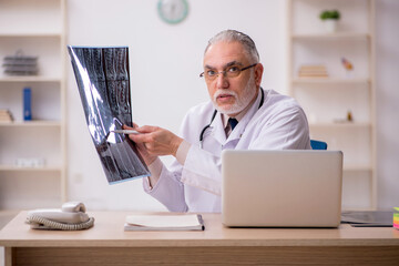 Old male doctor radiologist working in the clinic