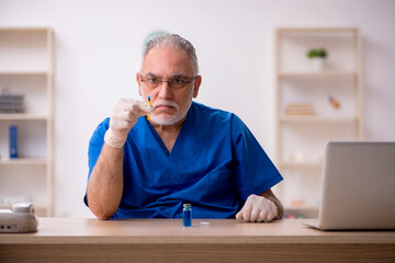 Fototapeta premium Old male doctor in vaccination concept
