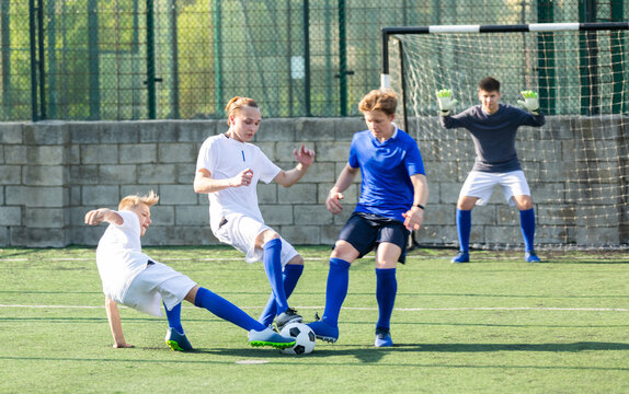 Young football player doing tackle to take ball away