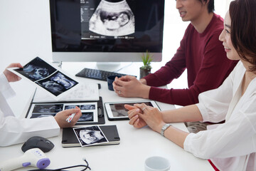 産婦人科医の説明を受ける夫婦