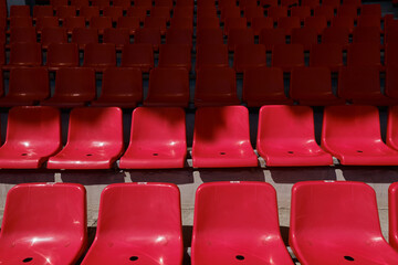 Empty stadium with red rows of chairs