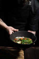 Chef holding freshly made asian pho bo