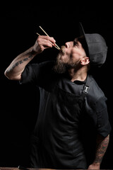 Chef tasting freshly made food with chopsticks
