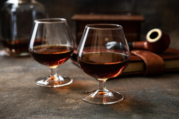 Two glasses of brandy or cognac on  dark table