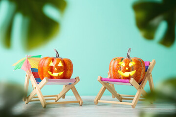 Halloween pumpkin jack o lantern with funny face creative concept on tropical beach chair