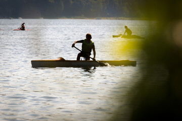 Człowiek płynący na kajaku po jeziorze.