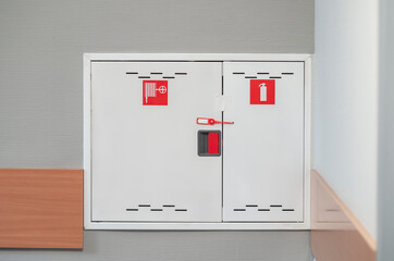 Fire extinguishers cabinet. Extinguishers cabinet on grey wall background in office building,...