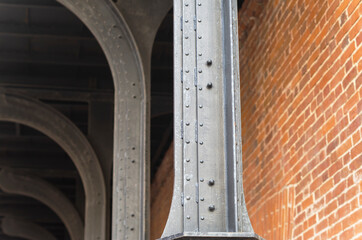 Metal construction beam and brick wall. Nodal point of building framework. Abstract background on...