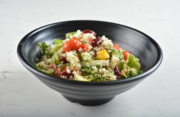 couscous healthy grain salad bowl with corn, bean, carrot and salad dressing sauce in white marble healthy poke bowl menu