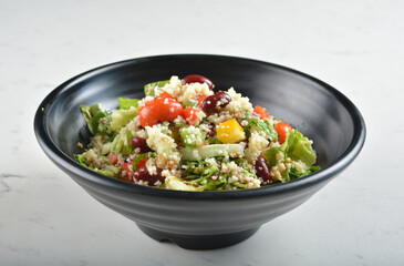 couscous healthy grain salad bowl with corn, bean, carrot and salad dressing sauce in white marble healthy poke bowl menu