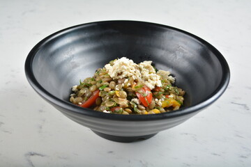 trio quinoa grain salad bowl with avocado, tomato, pea bean, carrot and brown rice in black bowl in white marble healthy poke bowl menu