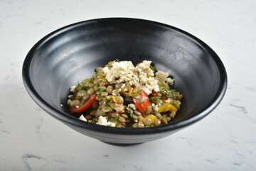 trio quinoa grain salad bowl with avocado, tomato, pea bean, carrot and brown rice in black bowl in white marble healthy poke bowl menu