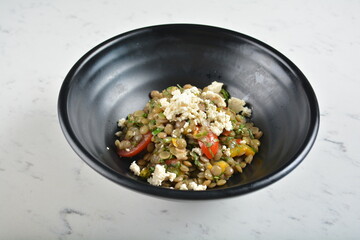 trio quinoa grain salad bowl with avocado, tomato, pea bean, carrot and brown rice in black bowl in white marble healthy poke bowl menu