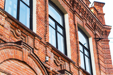 Beautiful red brick masonry decorating the windows on the wall of the house, an impressive...