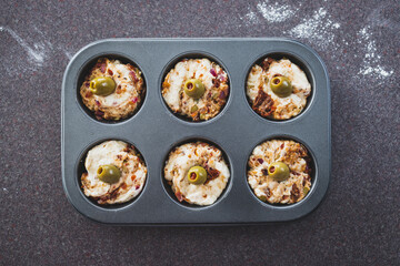 vegan focaccia savory muffins with sundried tomatoes and olives before getting baked in the oven, healthy plant-based food
