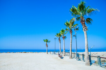 Beautiful beach in sunny summer day. Turquoise ocean water and blue sky with clouds . Natural background for summer vacation, soft focus, space for text