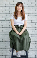 Smiling elegant woman in dress on brick wall background