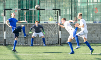 Obraz premium Youthful football players challenging for ball in midfield zone