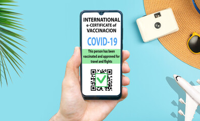 Coronavirus vaccination certificate or vaccine passport for travellers concept. COVID-19 immunity e-passport in the smartphone mobile app for international travelling. Blue background with camera and