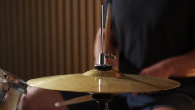 Drummer plays sticks on a drum kit, setting the rhythm