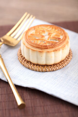 A moon cake and a knife and fork are ready to eat