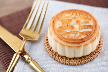 A moon cake and a knife and fork are ready to eat