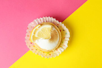 Tasty lemon cupcake on two tone background