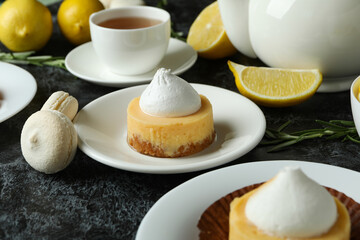 Concept of tasty breakfast with lemon cupcakes and macaroons